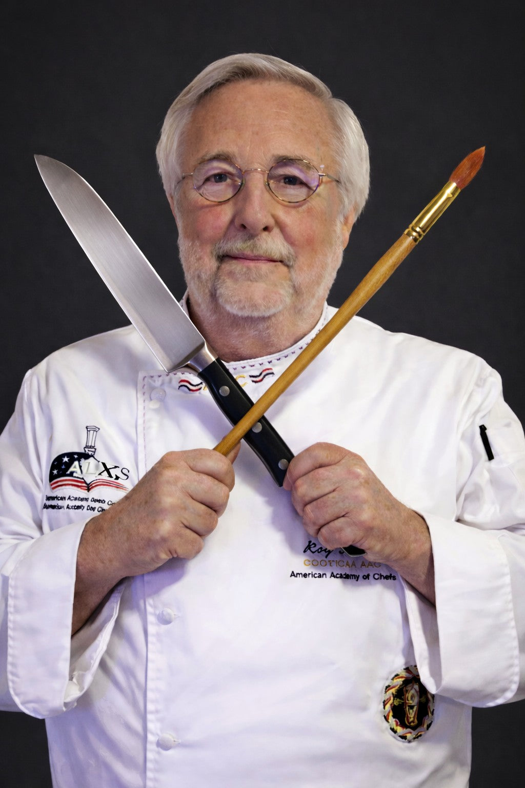 Gary L. Fuller holding a chef's knife and artist's paintbrush