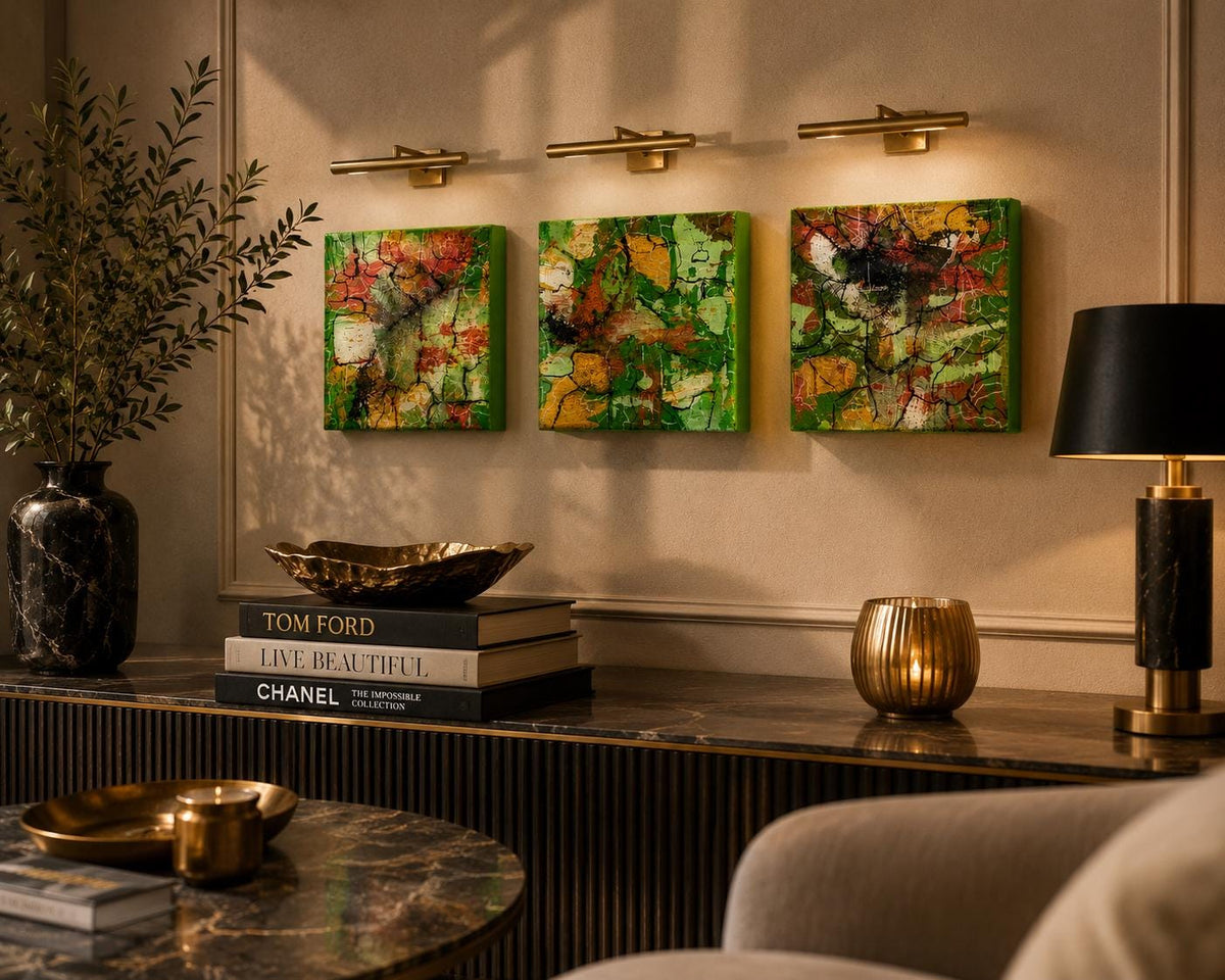 Three Spring Mosaic 4×4 abstract wood panels displayed beneath picture lights in a warm interior